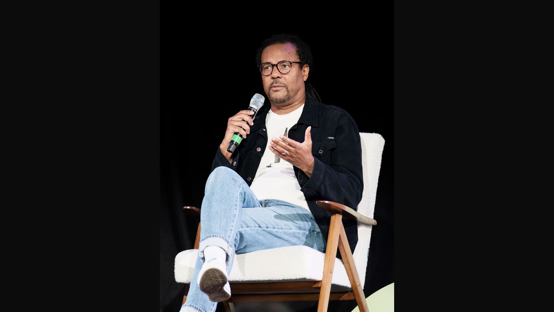 Archive photograph of Colson Whitehead seated on stage speaking into a microphone at the Edinburgh International Book Festival in August 2026