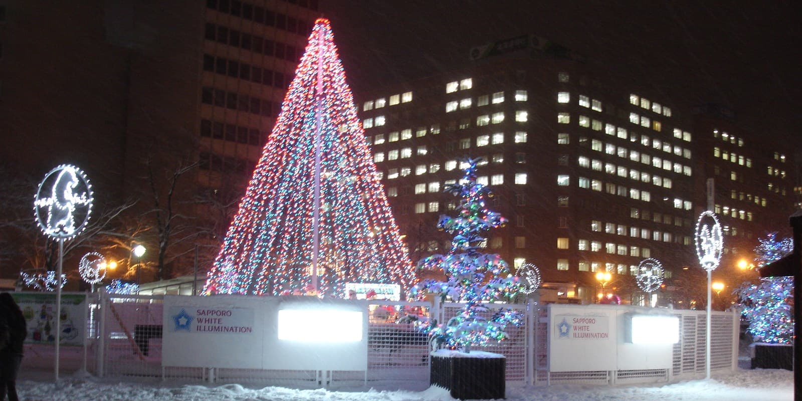 Archive photograph of colourful illuminated trees beside snow-covered paths in Sapporo in December 2012.