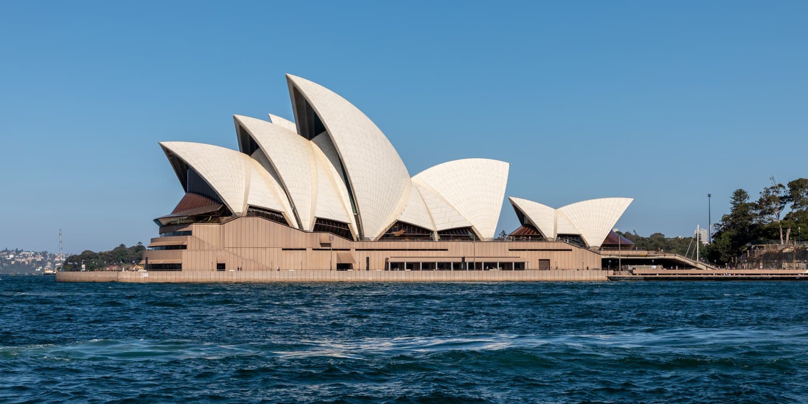 The white sails of the Sydney Opera House seen across the harbour on a clear day in 2019