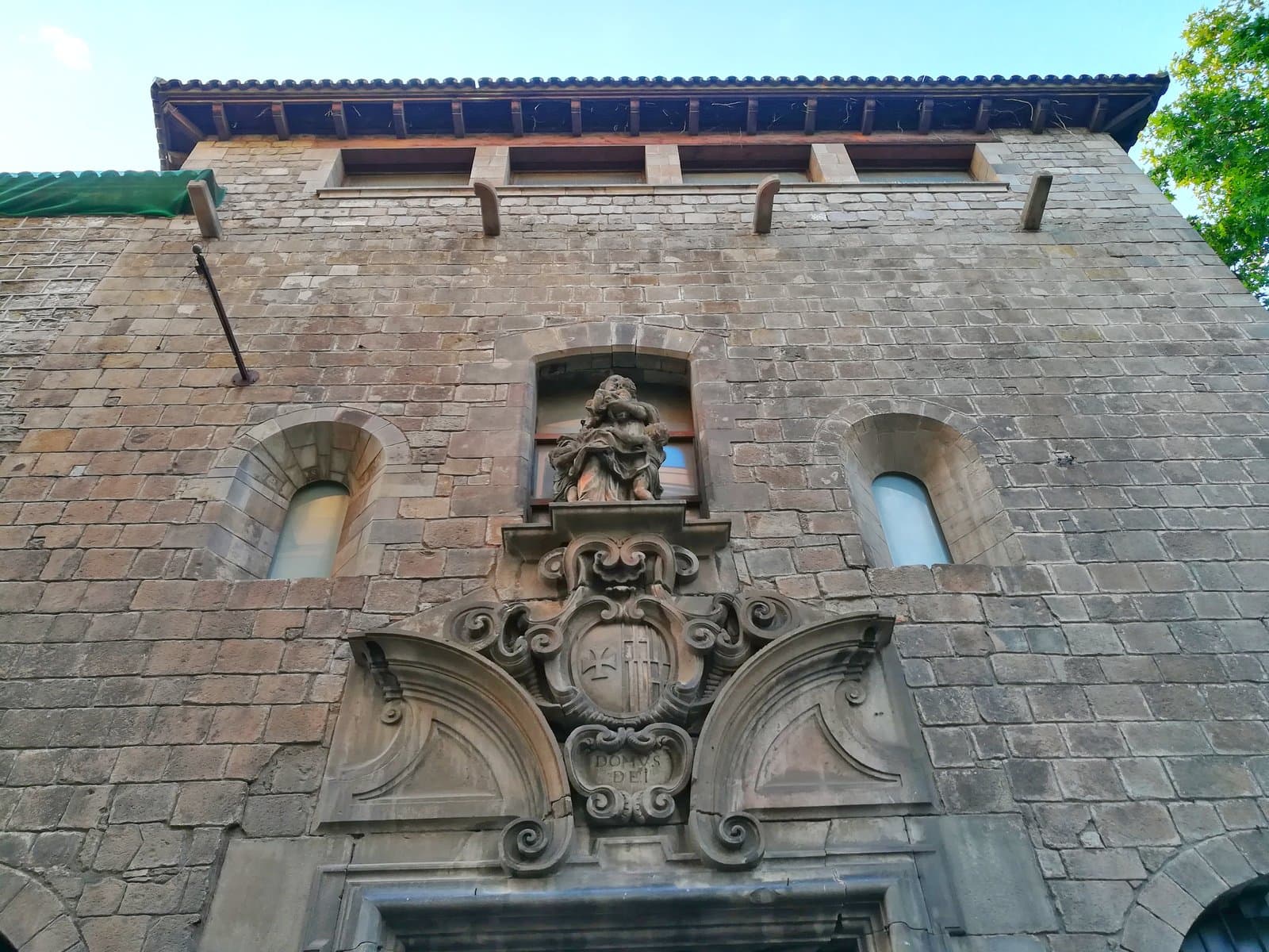 The historic stone façade and Baroque doorway of La Capella in Barcelona, photographed in May 2021