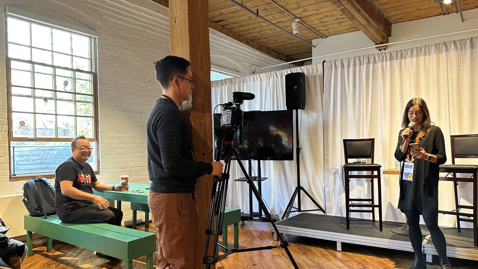 A camera records a Reel Asian Backstory event in 2023